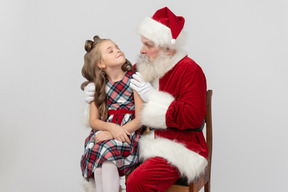 Kid girl sitting on santa's knees