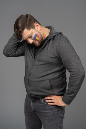 Three-quarter view of a puzzled male football fan touching head