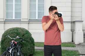 A man taking a picture with camera outside