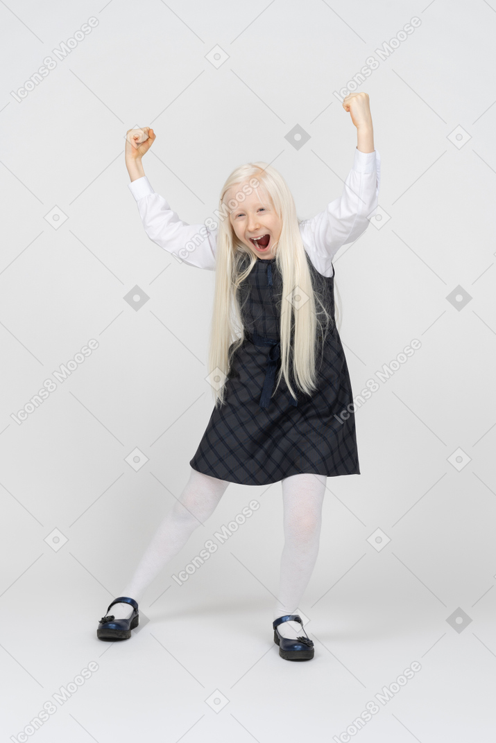 Schoolgirl holding hands up and cheering excitedly