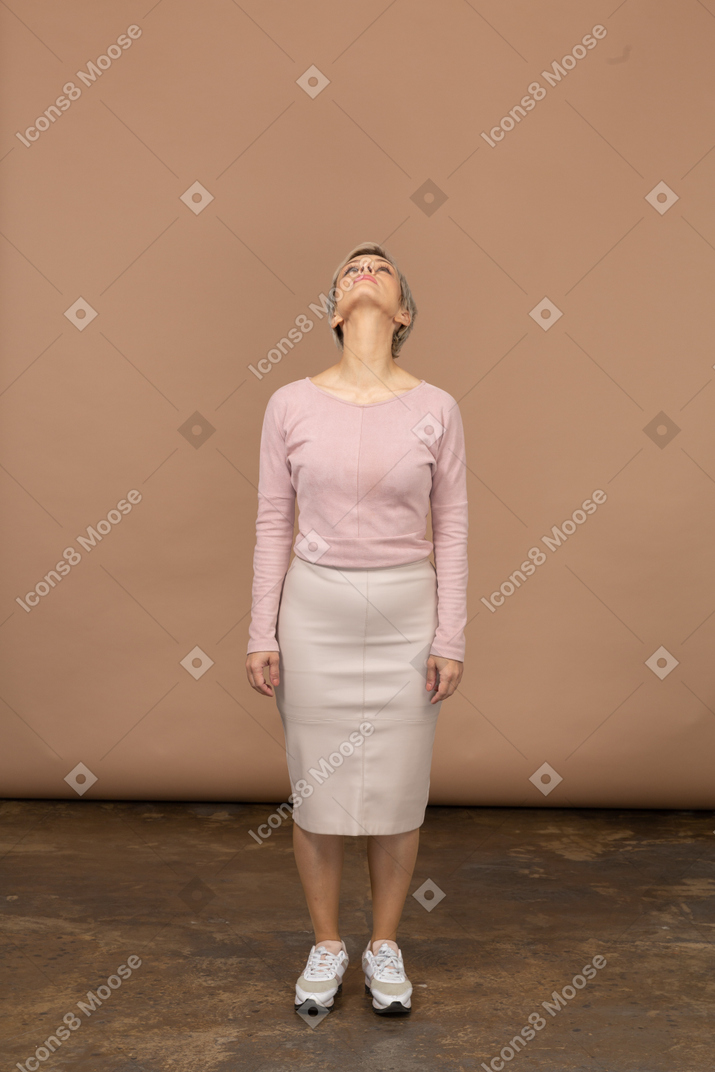 Вид спереди женщины в повседневной одежде, смотрящей вверх