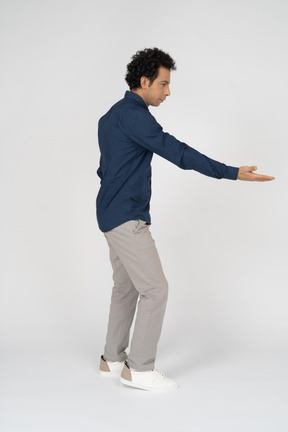 Seitenansicht eines mannes in freizeitkleidung, der mit der hand zeigt