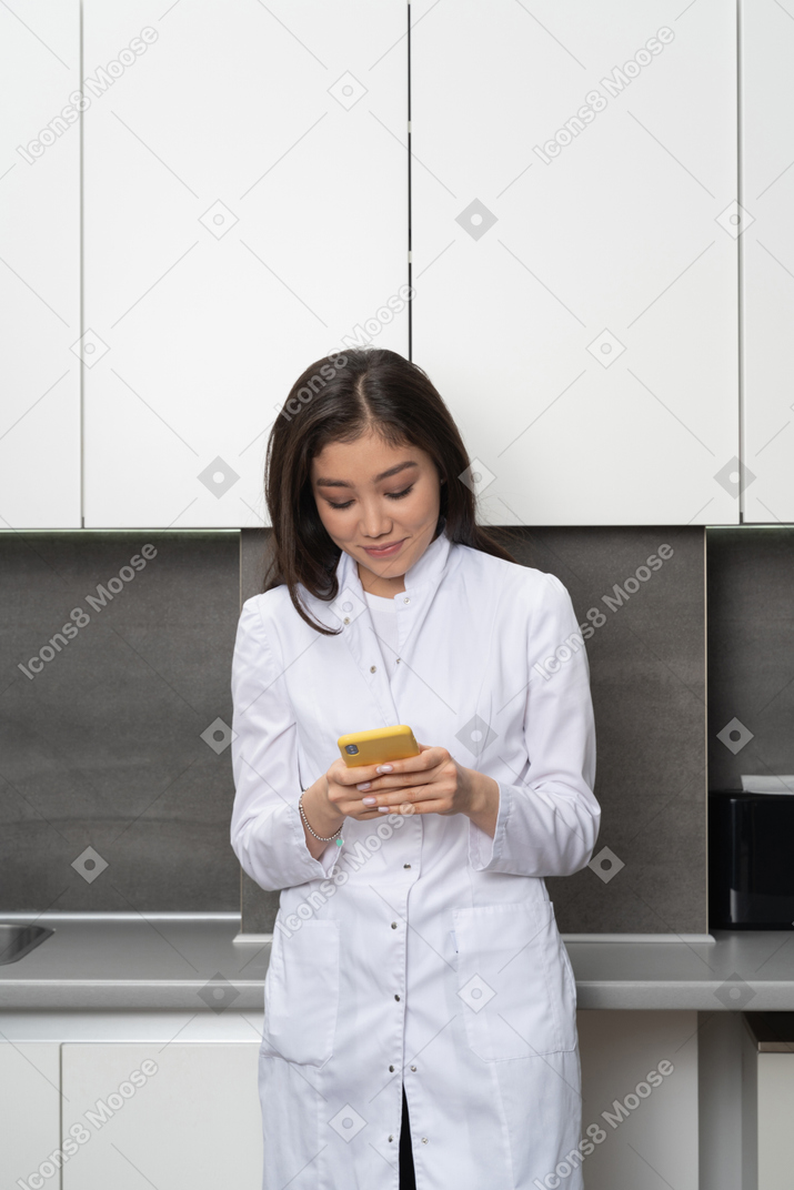 Vista frontale di un'infermiera in chat tramite telefono