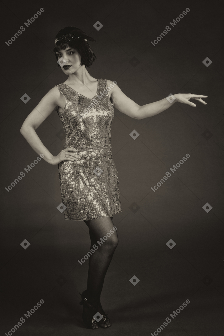 Woman in sequin dress posing in the dark