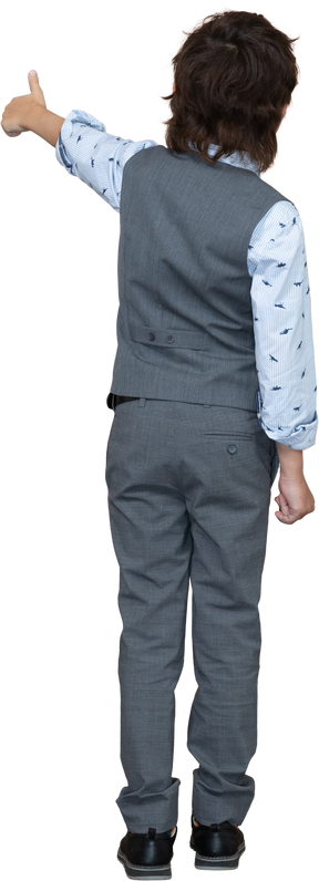 Vista trasera de un niño con traje gris que muestra el pulgar hacia arriba