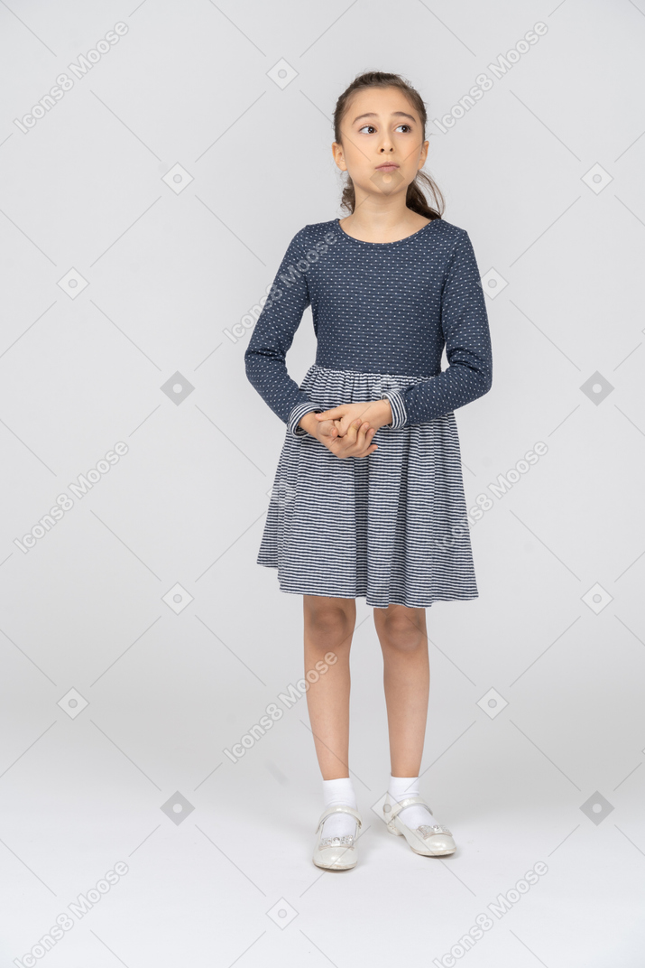 Front view of a girl clasping hands and looking to the side uncertainly