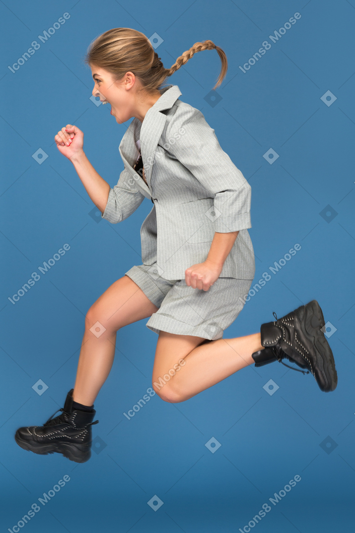 Excited young woman making a yeah gesture in a jump
