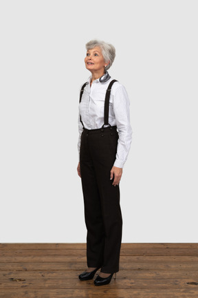 Vista di tre quarti di una donna anziana promettente vestita con abiti da ufficio