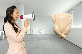 Mujer gritando en un megáfono a un pollo