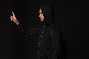 Hacker guy standing into dark and like touching something with a finger