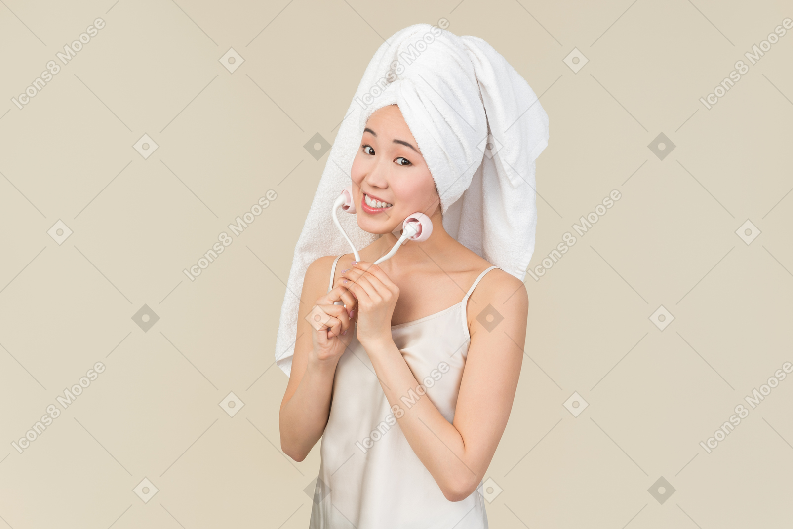Smiling young asian woman doing face massage with face massage roller