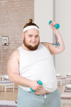 A fat man holding a pair of green dumbs