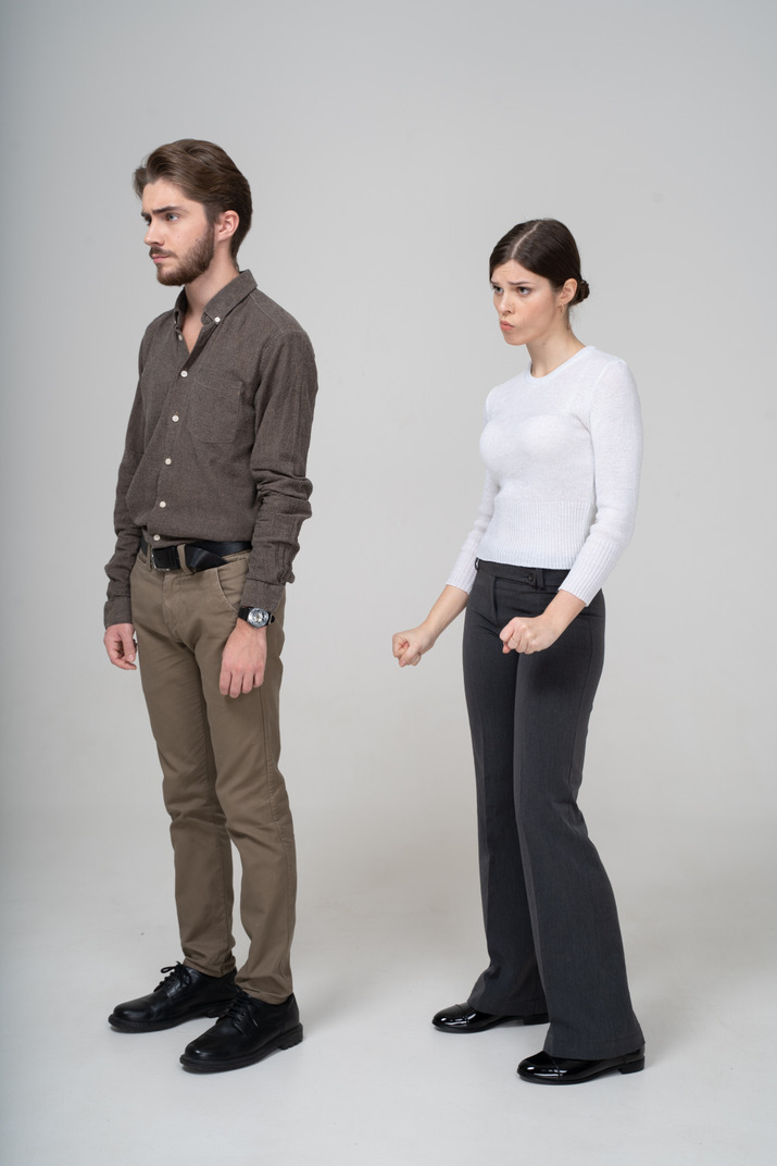 Three-quarter view of a moody young couple in office clothing
