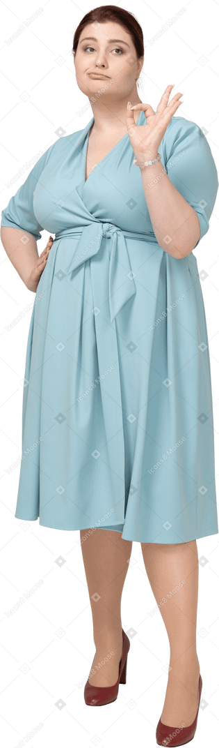 一个穿着蓝色裙子的女人的正面图，上面有 ok 的手势