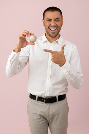 Attractive man holding a iota coin