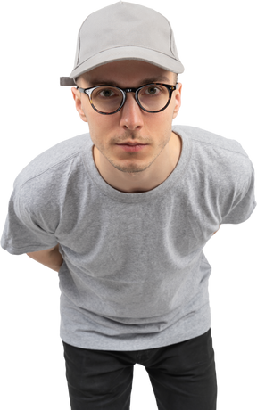 A man in gray t-shirt and gray cap staring at the camera