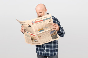 Bearded man reading a newspaper