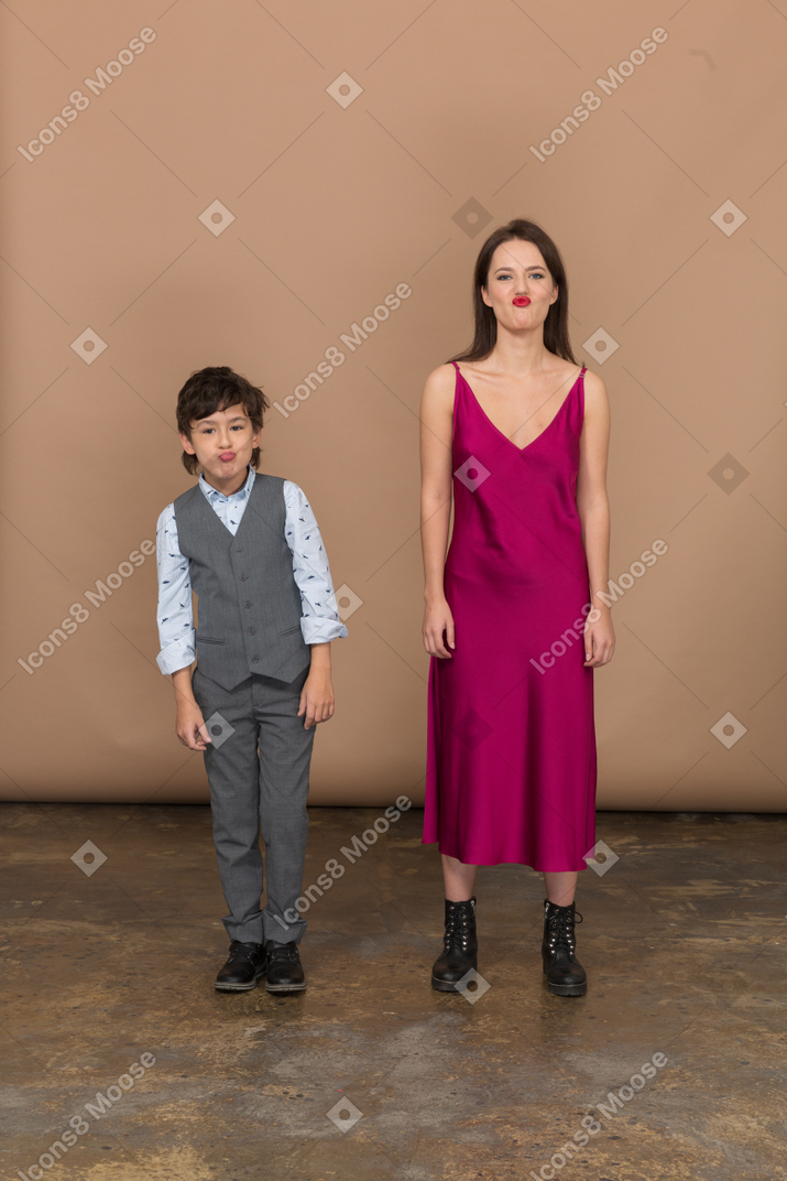 Menino e mulher olhando para a câmera