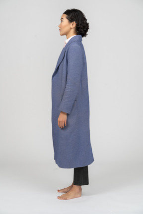 Side view of a wide eyed woman in blue coat