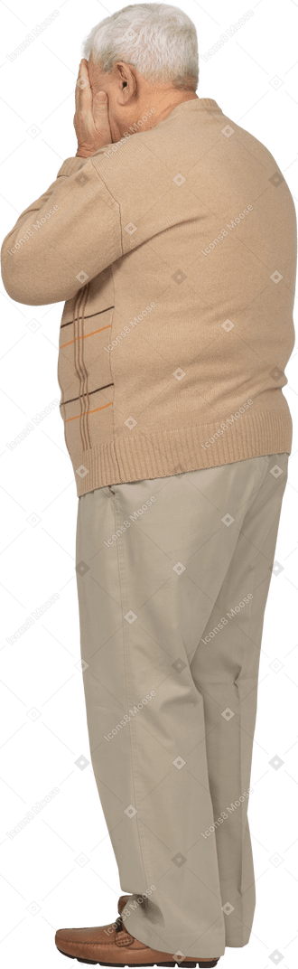 Old man in casual clothes covering face with hands