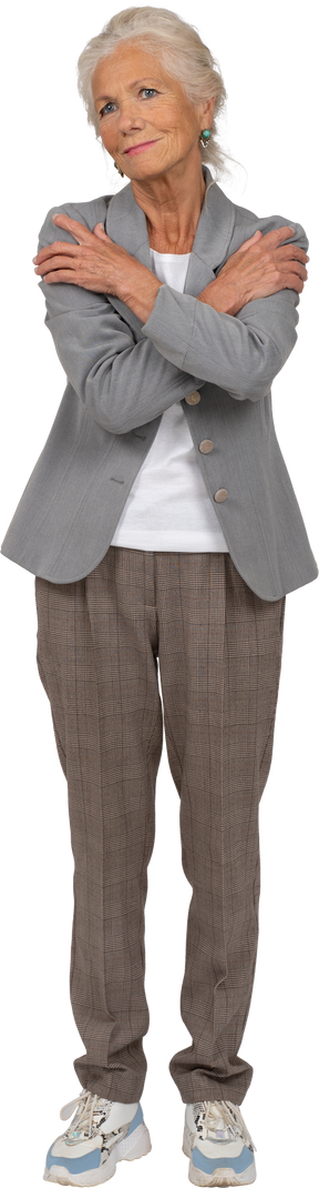 Front view of an old lady in suit hugging herself