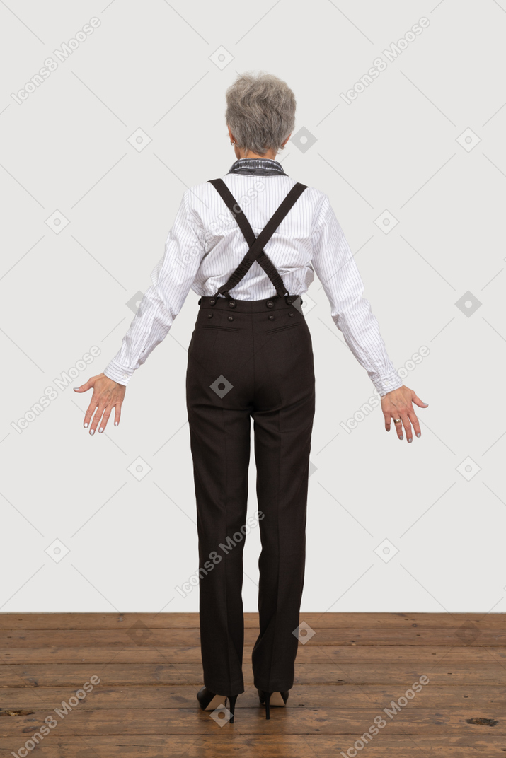 Вид сзади на старушку в офисной одежде, раскинувшую руки