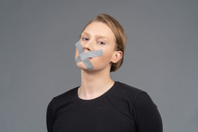 Three-quarter view of person with duct tape on mouth