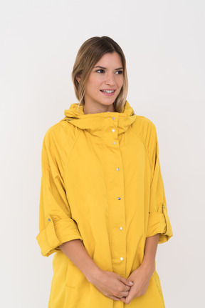 Mulher em amarelo anorak em pé com as mãos postas