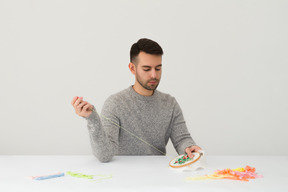 Hübscher junger mann, der stickerei tut