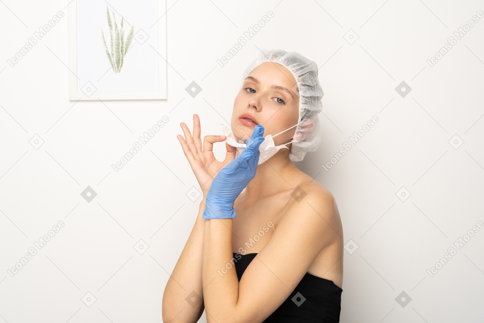 Mujer joven con gorra quirúrgica quitando la máscara