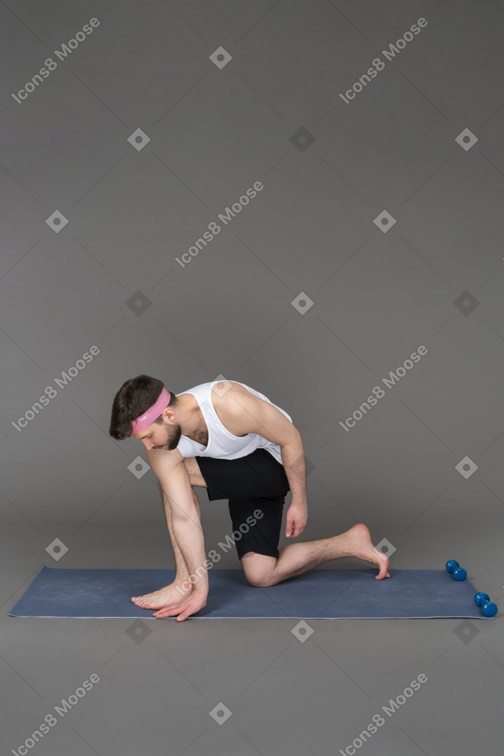 Young man exercising on a fitness mat