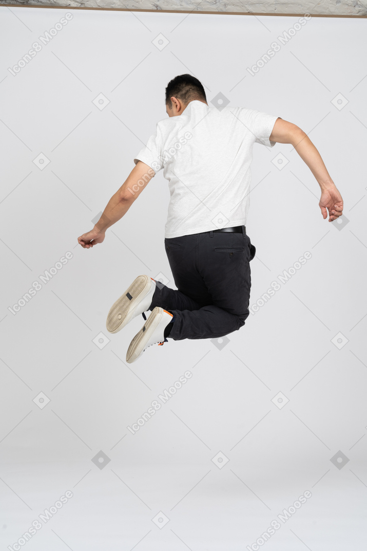 一个穿着休闲服的男人跳得很高的后视图