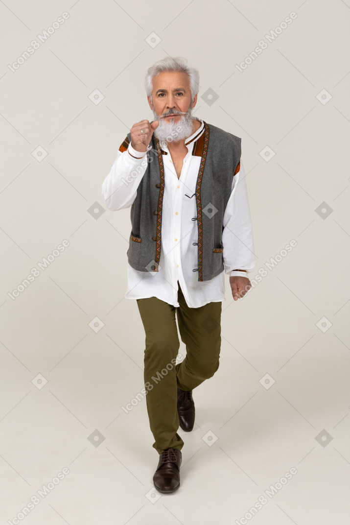 Man in casual clothing walking with raised fist