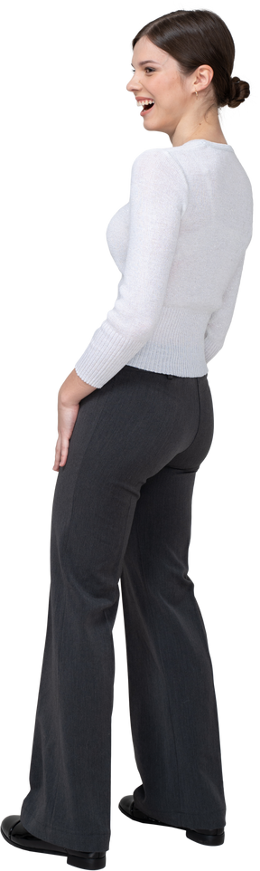 Vista posteriore di tre quarti di una giovane donna che ride in abiti da ufficio