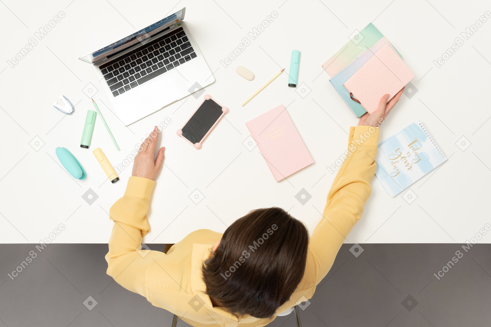 A female office worker at the table holding a notebook