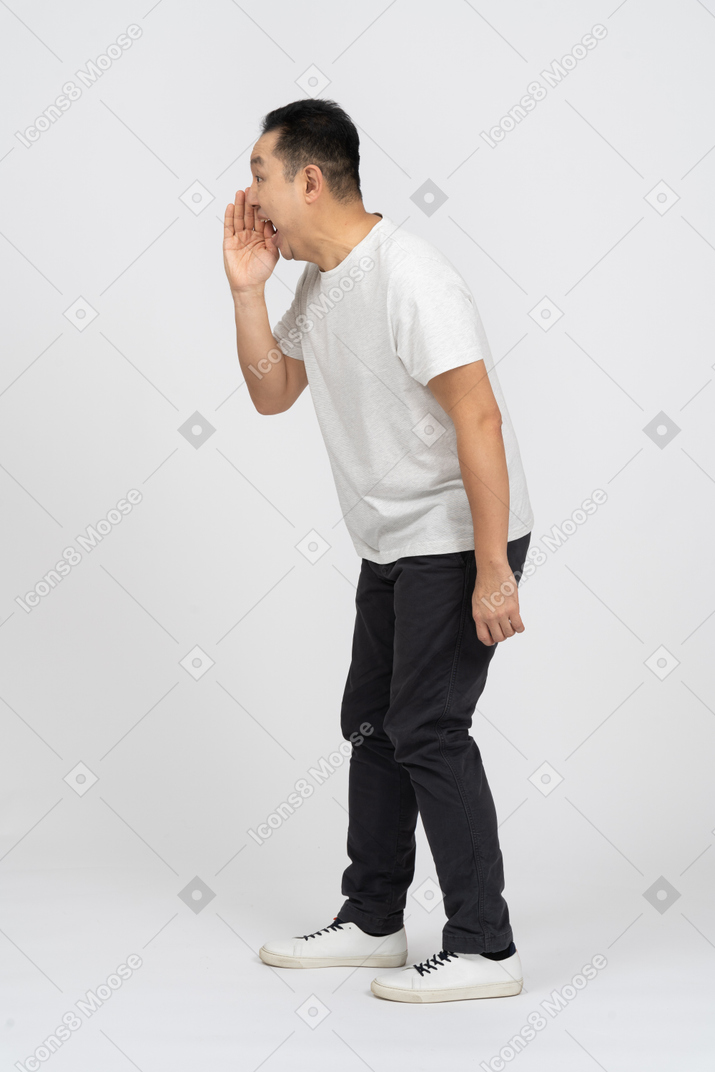 Vista lateral de um homem em roupas casuais chamando alguém