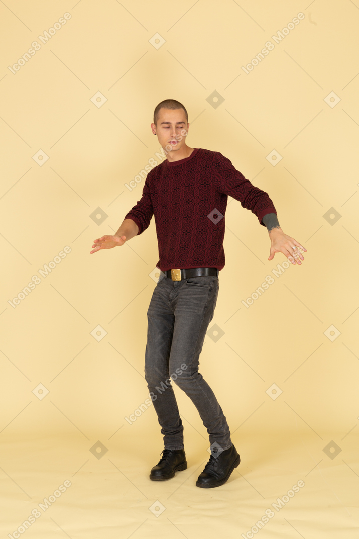 Three-quarter view of a dancing young man in red pullover