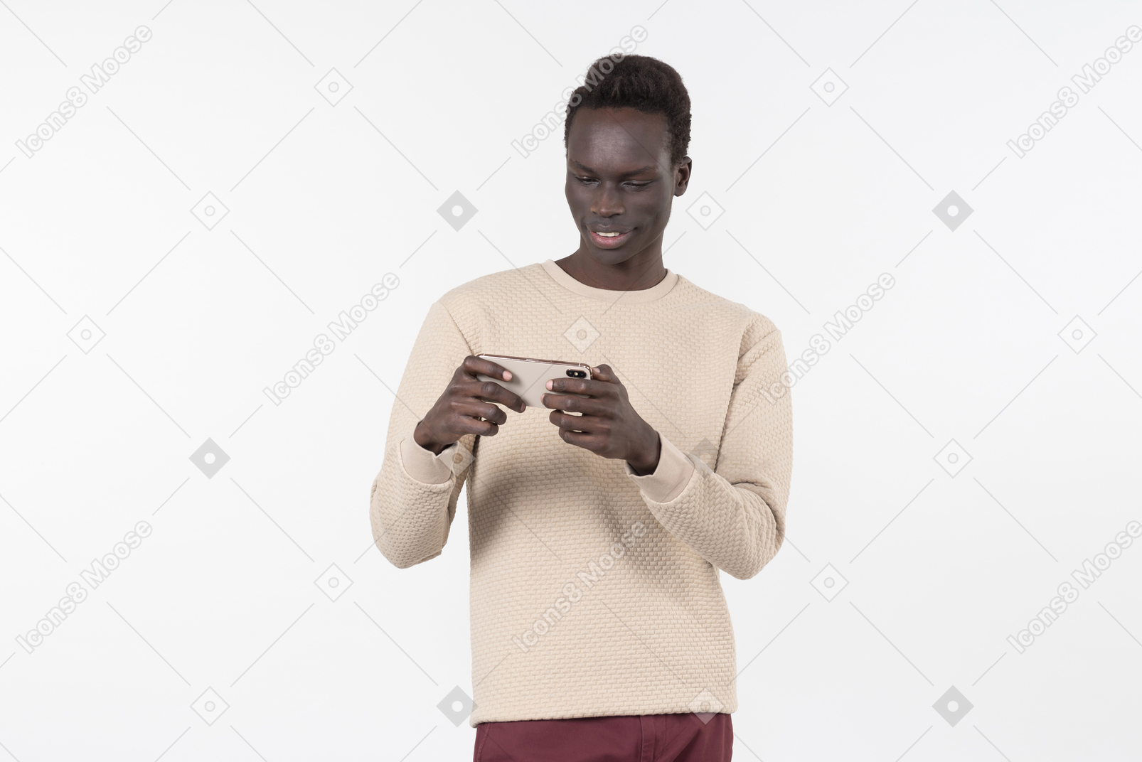 Young black man in a grey sweater using his smartphone