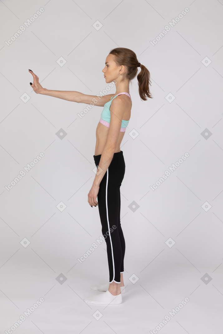 Vista lateral de una jovencita extendiendo su brazo.