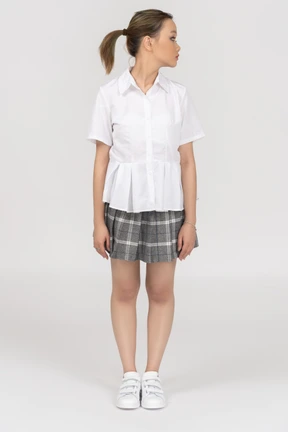 A young woman standing still with her head turned aside