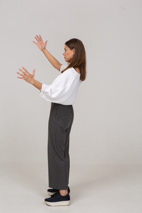 Side view of a young lady in office clothing showing a size of something