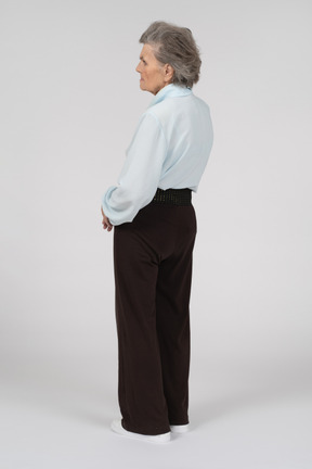 Vista posteriore di tre quarti di una donna anziana che sembra preoccupata