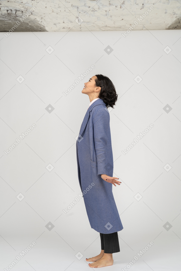 Excited woman in coat stretching up