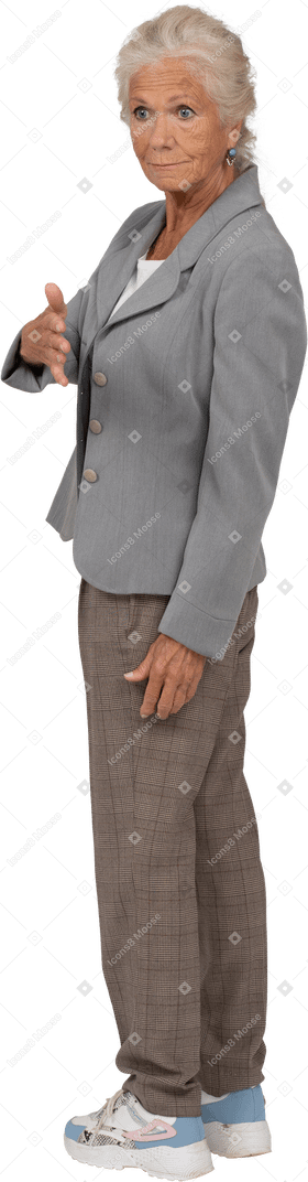 Side view of an old lady in suit giving a hand for shake