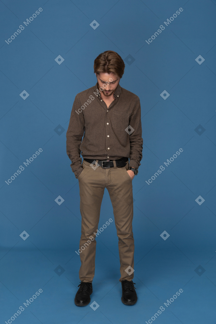 Serious young man standing with his hands in pockets