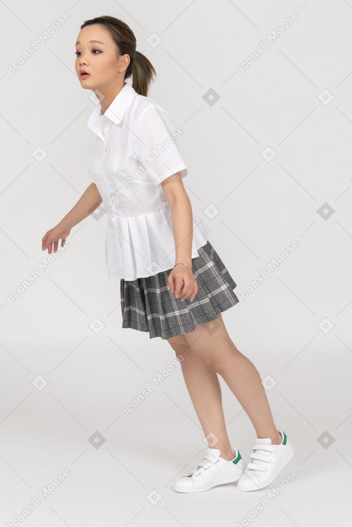 Uma jovem garota asiática curvando-se para a frente