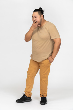 Plus size homem asiático usando os dedos para assobiar