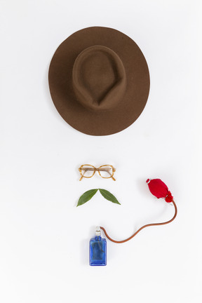 Sombrero de fieltro, gafas y spray de perfume.