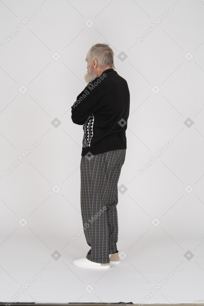 Back view of old man standing with crossed arms