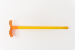 Yellow and orange rake on white background